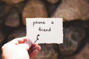 Someone holding a piece of paper that says "Phone a friend". Therapy for anxiety in Portland, OR can be just what you need to work through analysis paralysis. Get started with us today!