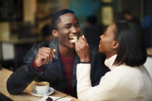 An individual giving their partner a bite of their food while laughing together. Anxiety counseling in Portland, OR can help you with relationship anxiety & attachment styles. Our anxiety therapists would voe to support you. 