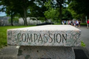 The word "COMPASSION" engraved into a concrete bench. Representing how therapy for anxiety in Portland, OR can help you build self-compassion skills. Reach out today!