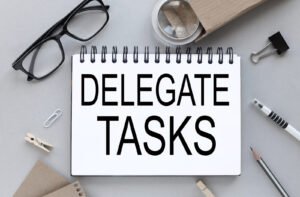 A piece of white paper that reads "DELEGATE TASKS" surrounded by office supplies. Discover how anxiety therapy in Portland, OR can help you delegate tasks & reduce anxiety. Reach out today to get started!