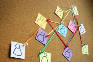 Different sticky notes on a cork board with string attaching each. This represents how delegating tasks can help with perfectionism. Learn more coping strategies with our anxiety counseling in Portland, OR. 