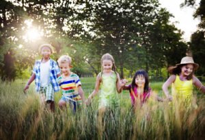 A group of diverse children running together in a field of grass. Child anxiety counseling in Portland, OR is here to support your family. Help your child thrive today. 
