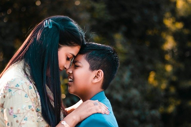 Parent and child touching foreheads in a moment of connection outdoors, symbolizing calm support and emotional closeness in managing child anxiety.