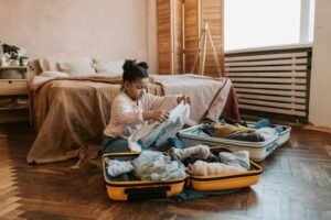 Young girl packing her suitcase on the floor, appearing focused and quiet—illustrating how anxiety in children may be misread as willfulness or independence.