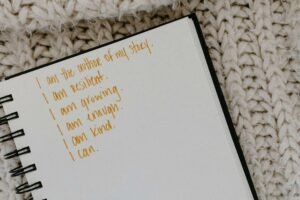 A journal that reads "I am the writer of my story, I am resilient. I am growing. I am enough. I am kind. I can." Representing how positive affirmations can help with anxiety management. Discover how anxiety therapy in Portland, OR can help.