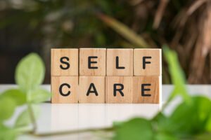 "Self care" spelled out on wooden blocks. This represents how trauma counseling in Portland, OR can help you build a self-care plan. Reach out today to start healing. 