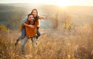 happy couple playing piggyback in fall